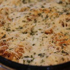 a casserole dish is covered with cheese and herbs