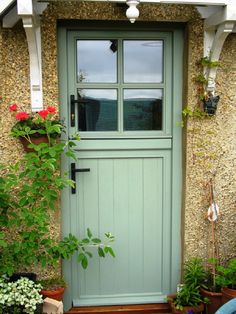 a green front door with potted plants outside