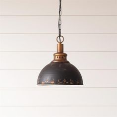 an old - fashioned light fixture hangs from a chain on a white shipboard wall