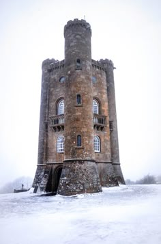 a very tall tower sitting in the middle of a snow covered field with lots of windows