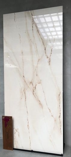 a large white marble slab with a wooden box on the floor in front of it