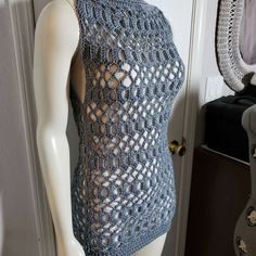 a mannequin wearing a blue knitted top with an openwork design on it