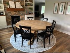 a dining room table surrounded by chairs in front of a fireplace