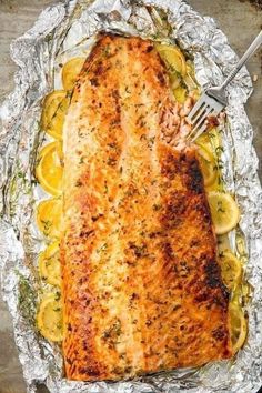 a piece of fish on foil with lemon slices