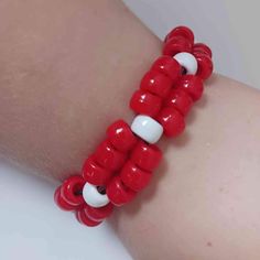 a red and white bracelet on someone's arm