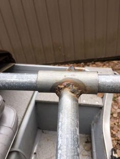 a metal pole that has some rust on it and is attached to the side of a building