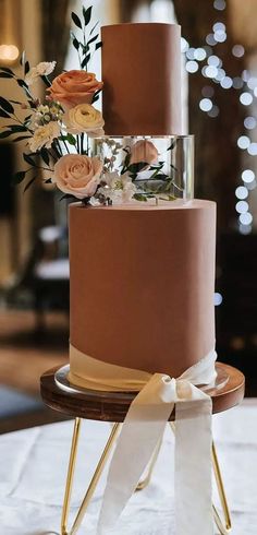 a three tiered cake with flowers on top