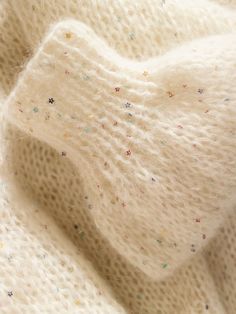 a white sweater with multicolored sprinkles on it