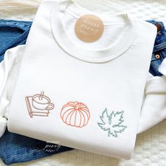 Fall sweatshirt, Embroidered Book Leaves Crewneck Sweatshirt, Pumpkin Patch, Pumpkin Sweater, Autumn Shirt Thanksgiving Sweatshirt, Gift ---HOW TO ORDER---   FOR EACH SHIRT CHOOSE: **Shirt type, size and color ---UNISEX SIZING--   Please see size chart in the pictures ---PRODUCT DETAILS--- Gildan Crewneck UNISEX Sweatshirt 50% cotton, 50% polyester Pre-shrunk Air jet yarn for softer feel and reduced pilling Double-needle stitched collar, shoulders, armholes, cuffs, and hem Gildan Crewneck UNISEX White Embroidered T-shirt For Fall, White T-shirt With Embroidered Text For Fall, Fall Embroidered Crew Top, Embroidered Crew Sweatshirt For Fall, Custom Embroidery Long Sleeve T-shirt For Fall, White T-shirt With Custom Embroidery For Fall, Custom Embroidered White T-shirt For Fall, White Embroidered Logo T-shirt For Fall, White Custom Embroidered T-shirt For Fall