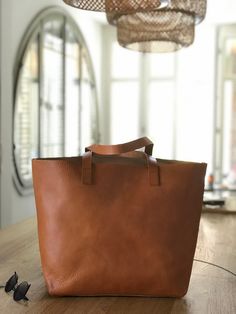 "Oversized camel leather bag, made with the highest quality veg tanned leather. Its clean design and its 7 inches depth makes this beautiful bag a versatile bag to carry many things. Features: - Highest quality Full Grain Veg Tanned leather - Aprox Size: 14 in wide at the bottom, at the top, the width depends on how full is the bag, but it should be around 15-17 inches (36 cm at bottom - wider at the top - maybe 40-42 cm) - easily fits a 15\" laptop 13 in high (33 cm) 7 inches deep (18 cm) - 3 b Rectangular Caramel Shoulder Bag For Daily Use, Everyday Bags With Leather Lining In Natural Color, Natural Leather Lined Everyday Bags, Caramel Top Handle Bag For Everyday Use, Rectangular Caramel Bag With Leather Handles, Caramel Rectangular Bags With Leather Handles, Everyday Natural Bags With Leather Lining, Everyday Caramel Satchel Shoulder Bag, Everyday Caramel Shoulder Bag With Leather Lining