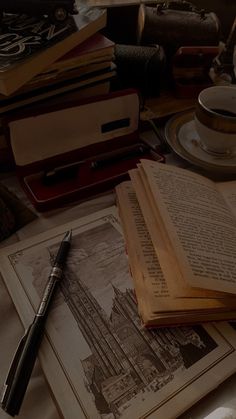 an open book sitting on top of a table next to a pen