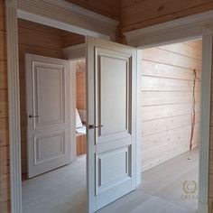 an empty room with wooden walls and white doors