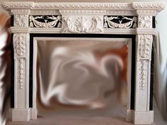 a white fireplace with an ornate design on the mantle