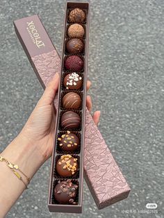 a person holding a box of chocolates in their hand