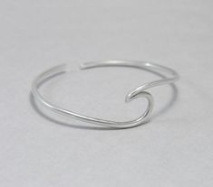 Wave cuff bangle, sterling silver, beach jewellery, ocean, beach bracelet, minimalist, adjustable, gift for her, one size Sterling silver solid cuff hand formed to a wave shape from 12 gauge (2 mm) wire. Comfortable to wear all day or sleep with and sturdy. This bangle is slightly adjustable and thus one size. It will fit most wrists (14 -18 cm / 5.5 - 7 inches wrist). But you can always ask for a different size. The bracelet above is not the exact one you will receive. Each one is handmade to o Minimalist Beach Bracelet Jewelry, Adjustable Silver Bracelets With Ocean-inspired Style, Adjustable Silver Bracelet With Ocean-inspired Style, Adjustable Silver Ocean-inspired Bracelets, Silver Adjustable Ocean-inspired Bracelets, Minimalist Resizable Bracelets For Beach, Minimalist Sterling Silver Jewelry For Beach, Minimalist Resizable Jewelry For Beach, Minimalist Adjustable Sterling Silver Oyster Bracelet