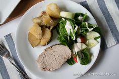 a white plate topped with meat and vegetables