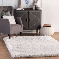 a living room with a gray chair and white rug