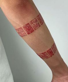 a person with a red and white tattoo on their arm