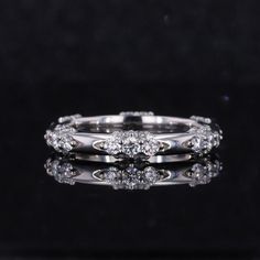 an image of a wedding ring with diamonds on it's side and reflection in the middle