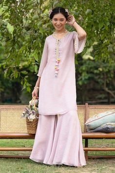 Pink tunic crafted from georgette lurex fabric, highlighted with intricate mirror and thread work detailing. Paired with a flared pant. - Aza Fashions Bohemian Palazzo Set For Summer Festive, Festive Summer Straight Kurta Pant Set, Festive Summer Tunic Palazzo Set, Festive Summer Tunic Sets, Summer Festive Tunic Palazzo Set, Bohemian Straight Kurta Sets For Spring, Bohemian Spring Sets With Straight Kurta, Bohemian Pant Set For Spring Festive Occasion, Summer Georgette Tunic Kaftan