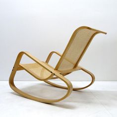 a wooden rocking chair sitting on top of a white floor