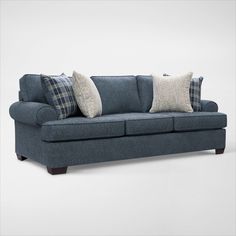 a blue couch with two pillows on it's back and one pillow on the arm