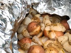 potatoes and onions in foil with seasoning on them