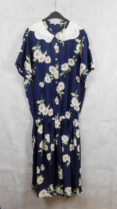 "Romantic summer dress by Roberto G Fontana, dark blue with daisy pattern, mid-length daisy floral dress, Peter Pan white collar, elastic low waist, short sleeve with buttons to the waist, made of 100% viscose, Size - D36, F38, GB10, I42 Perfectly preserved Shoulders: 47 cm /18.5\" Length: 121cm / 47.6\" Sleeves: 25 cm / 10\" Bust: 60 cm / 23.6\" Waist (elastic): 36 - 53 cm /14.2 -21\"" Navy Vintage Short Sleeve Dress, Retro Navy Dress For Spring, Vintage Daisy Print Dresses, Vintage Mid-length Floral Print Dresses, Casual Vintage Dress With Floral Print For Daywear, Casual Vintage Floral Print Dress For Daywear, Casual Vintage Floral Dress For Daywear, Navy Floral Print Summer Dress, Navy Retro Summer Dress