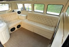 the interior of a boat with white leather seats and windows on both sides is shown