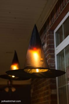 two lights that are on the side of a brick building in front of a window