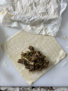 an uncooked tortilla sitting on top of a white plate next to a napkin