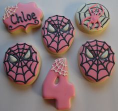 decorated cookies with pink frosting and black sprinkles are arranged on a table