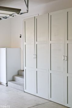 an empty room with white cupboards and stairs