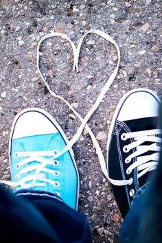 two pairs of shoes with white laces on them and a blue shoelace in the shape of a heart