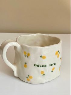 a white mug with yellow lemons on it