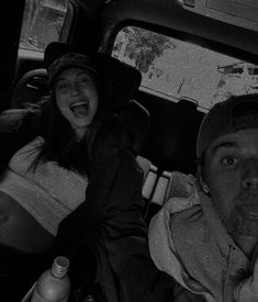 two people sitting in the back seat of a car with one person sticking his tongue out