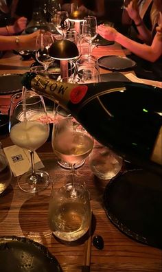 several glasses of wine on a table with people in the background