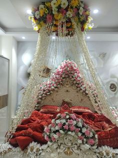 a canopy bed with flowers on it in the middle of a room filled with furniture