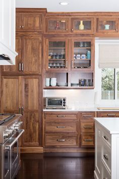 a kitchen with wooden cabinets and white counter tops