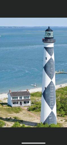 an aerial view of a lighthouse with the ocean in the background