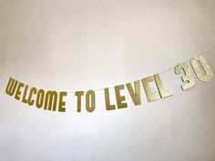 a welcome to level 30 banner hanging from a string with gold foil letters on it