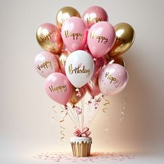 a cupcake with pink, gold and white balloons in it that say happy birthday