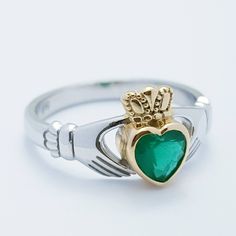 The perfect gift for you or someone close. Sterling silver claddagh ring set with green heart shaped stone with inclusions to look like genuine emerald. The hands represent friendship, the heart love and the crown stands for loyalty. This ring has been coated in a durable layer of 18k yellow gold, to maintain the color as long as possible please avoid contact with chemicals, lotions etc and keep in an airtight zip lock bag when not being worn. ---------------------------------------------------- Elegant Green Sterling Silver Heart Ring, Elegant Green Heart Sterling Silver Ring, Heart Cut Green Emerald Ring For Formal Occasions, Green Heart Cut Emerald Ring For Formal Occasions, Heart Cut Emerald Ring For May Birthstone, Formal Green Heart Cut Emerald Ring, Heart Cut Green Emerald Ring, Formal Green Heart Cut Rings, Green Sterling Silver Heart-cut Jewelry