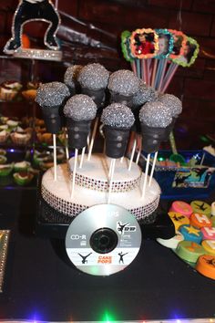 there are many cake pops on top of the table with a cd next to it