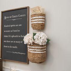 two baskets with flowers are hanging on the wall