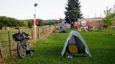 there is a tent in the grass next to a bike