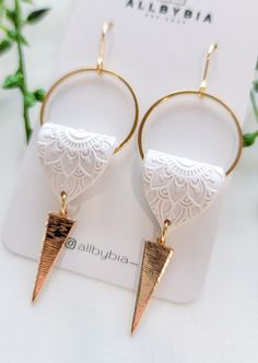 two pairs of earrings with gold and white details