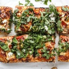 several square slices of pizza with spinach and cheese