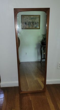 a large mirror sitting on top of a wooden floor