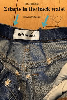 a pair of blue jeans with white flowers on them and the words, 2 darts in the back waist